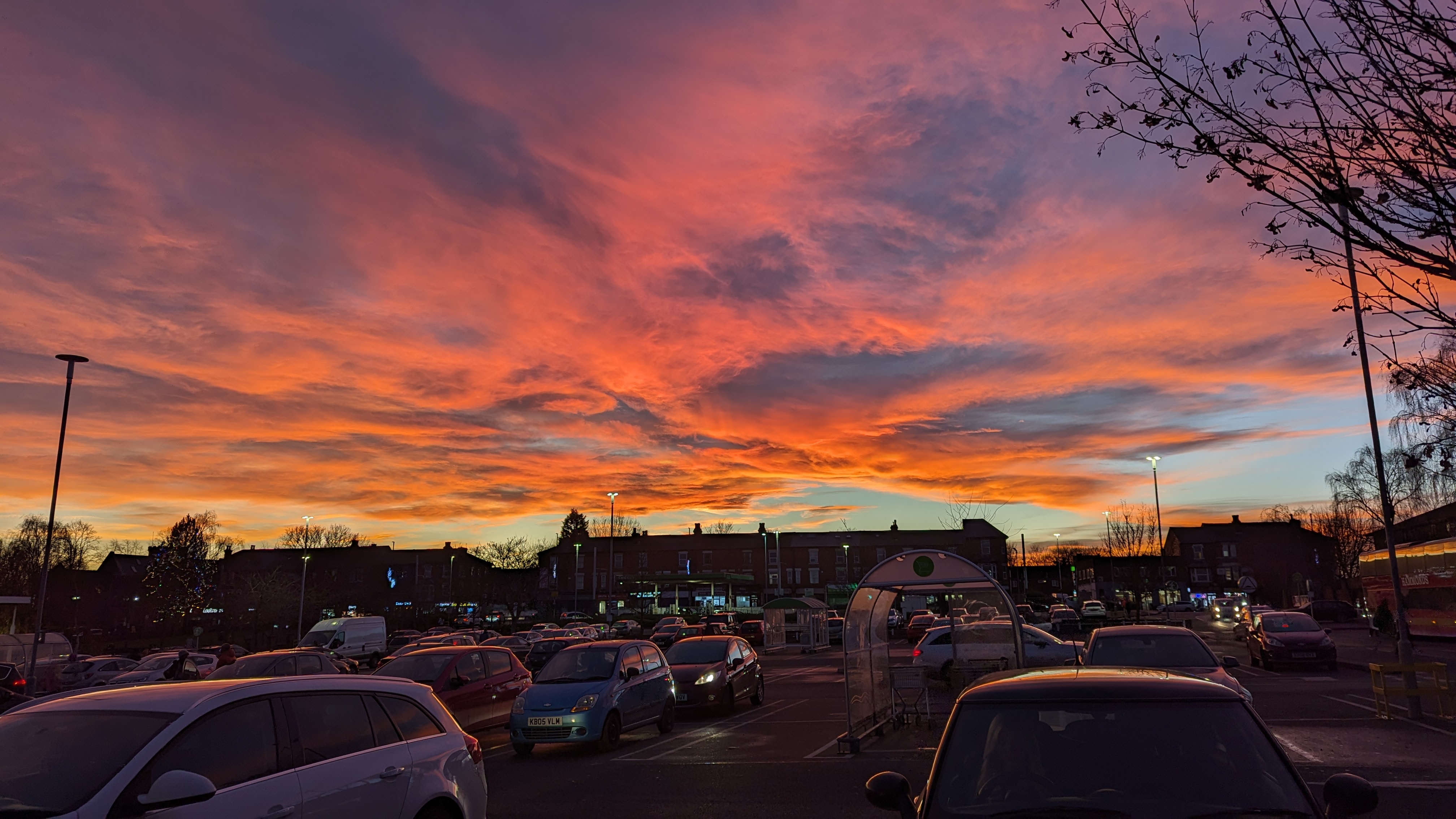 A photo taken from the car park at Asda in Hyson Green, with a view of the clouds over the car park, shining orange from the sunset, and looking pretty darn spectacular